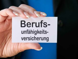 Eine Person in Businesskleidung hält eine Karte mit der Aufschrift 'Berufsunfähigkeitsversicherung'.