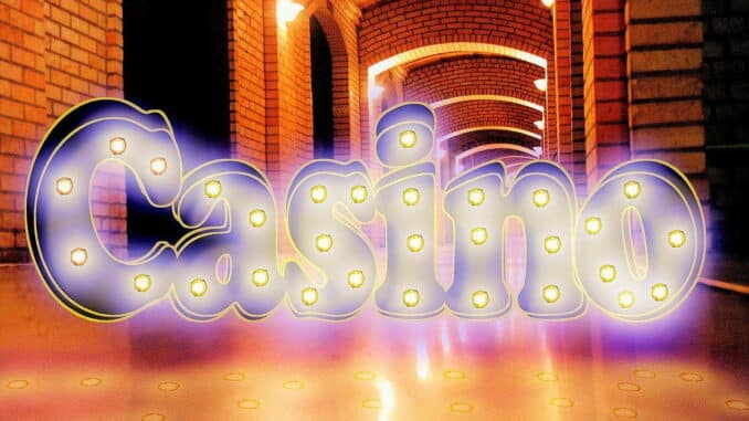 Das Bild zeigt ein leuchtendes Casino-Schild in Neonbuchstaben vor einer gemauerten Wand.
