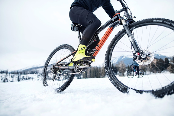 Eine Person fährt mit einem Mountainbike durch Schnee.