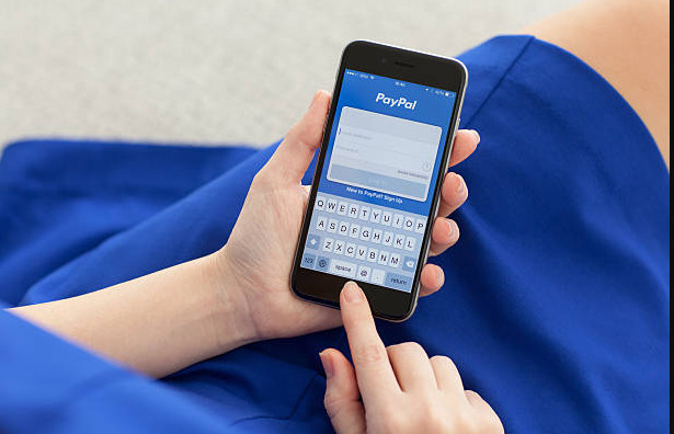 Eine Person nutzt die PayPal-App auf ihrem Smartphone, um eine Zahlung zu tätigen oder zu empfangen.