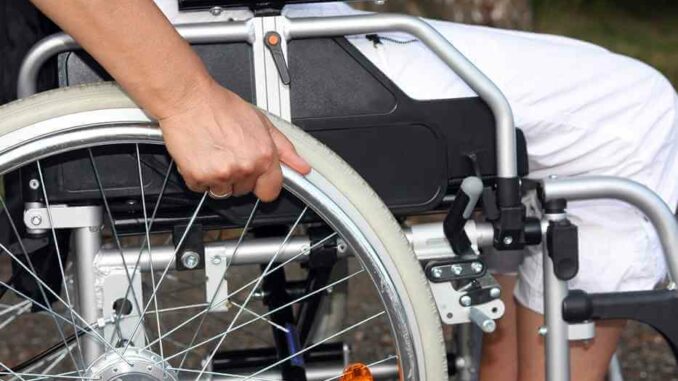 Eine Person im Rollstuhl hält das Rad fest.